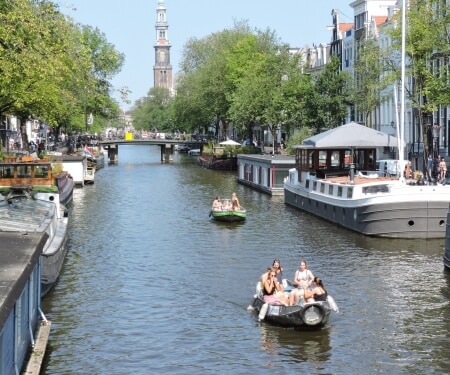 Zwei Boote fahren entlang der Amsterdamer Grachten.